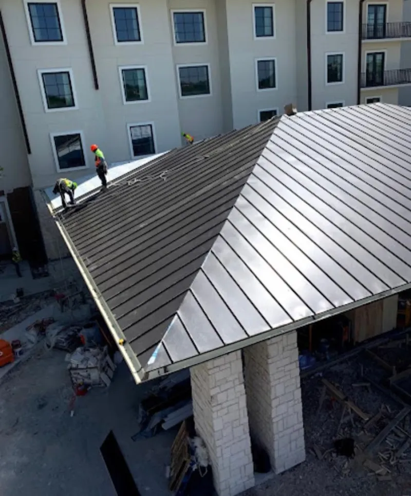 Crew installing standing seam metal roof panels on a commercial project in Novato